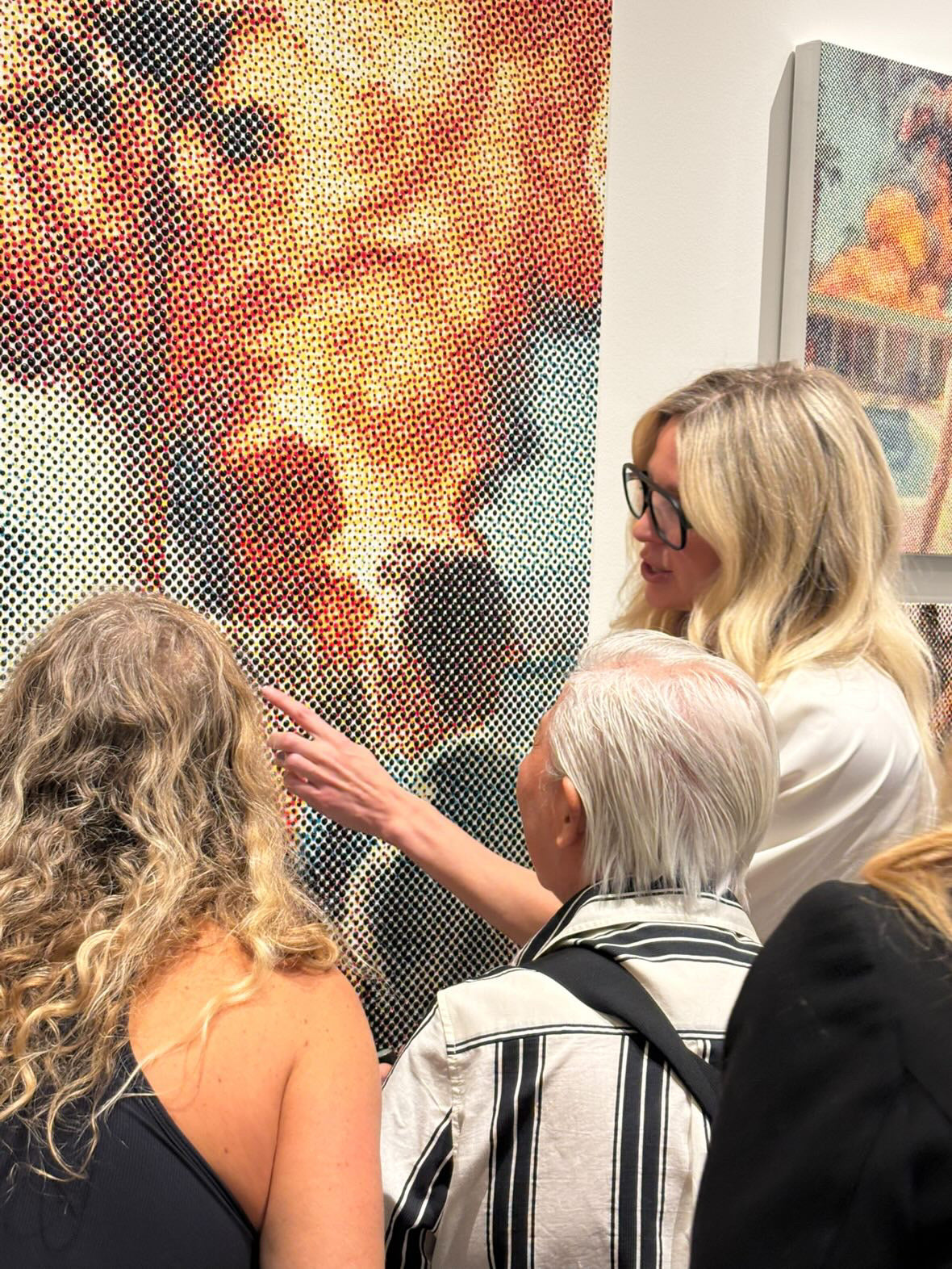 Maggie Hall with people looking at a piece of art  during her Holt Renfrew exhibition