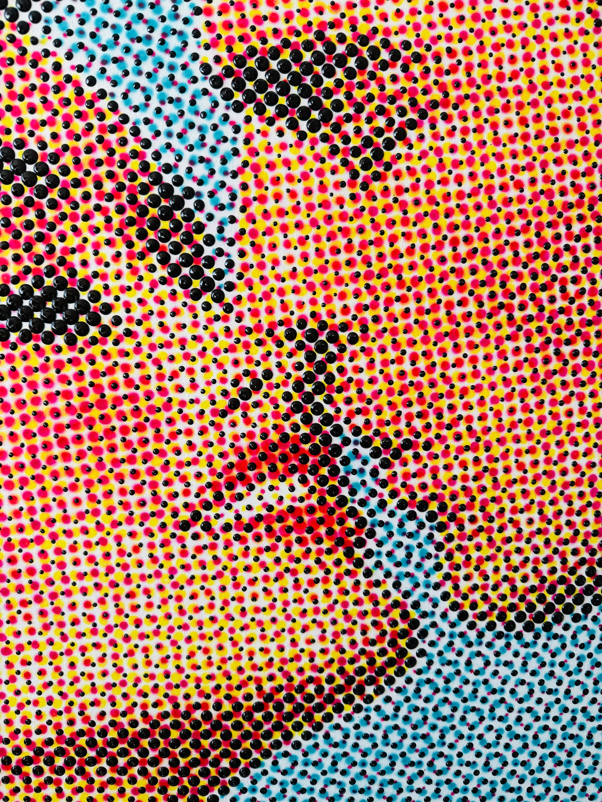 Closee up of hand painted, CMYK dots, showing a man and a woman about to kiss 